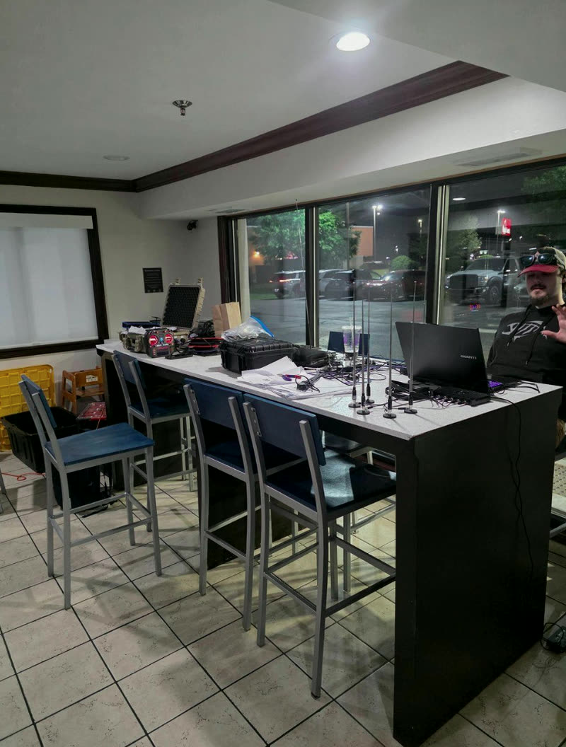 An operator running DaggerOS from a forward position at night, radio suite staged on the table.